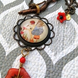 May include: A necklace with a glass pendant featuring a fairy painting, a twig charm, and red glass flower accents.