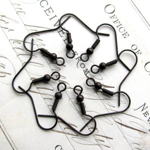 May include: Six antique bronze earring hooks with a spring clasp. The hooks are arranged in a circle on a white surface.