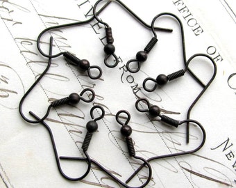 May include: Six antique bronze earring hooks with a spring clasp. The hooks are arranged in a circle on a white surface.