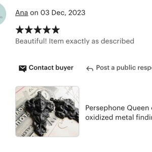 May include: Two black metal pendant charms featuring a stylized female face with a crown. The charms are oxidized and have a detailed design.