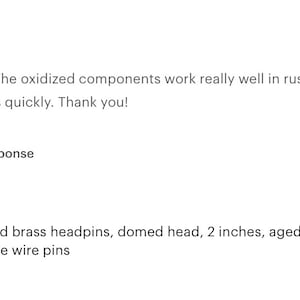 May include: A close-up of 50 black antique brass headpins. The headpins are 2 inches long and have a domed head. The headpins are 22 gauge wire pins.