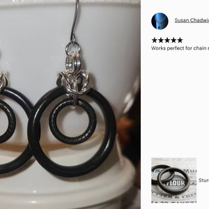 Puede incluir: Un par de pendientes de plata con anillos de cuero negro. Los pendientes est&aacute;n hechos con un dise&ntilde;o de malla de cadena y tienen un dise&ntilde;o de doble anillo.