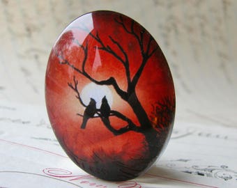 Lovebirds in a tree silhouette against a full moon, 40x30mm handmade glass oval cabochon, red sky, sunset, Mystic Moon