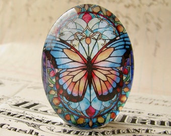 May include: A round glass cabochon with a stained glass design featuring a colorful butterfly with blue, pink, orange, and yellow wings. The butterfly is surrounded by a geometric pattern in shades of blue, red, and green.