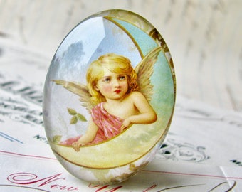 Victorian angel on the moon, handmade in this shop, glass oval cabochon, 40x30mm or 25x18mm, winged cherub, sky blue, yellow