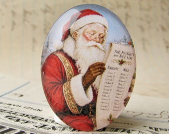May include: Oval-shaped Christmas ornament featuring Santa Claus reading a list. Santa is dressed in a red suit with white fur trim and a matching hat. The list reads "The Naughty and Nice List."