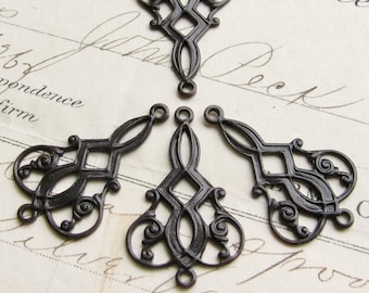 May include: Five antique bronze metal filigree charms with a diamond pattern and ornate details. Each charm has a loop at the top for hanging.