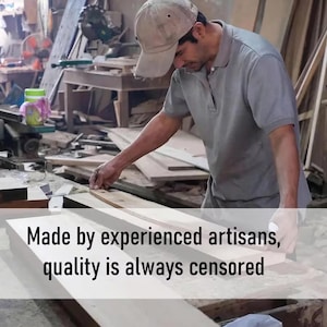K&ouml;nnte beinhalten: Ein Tischler in einer Werkstatt misst ein Holzbrett. Das Bild enth&auml;lt den Text "Made by experienced artisans, quality is always censored". Der Handwerker tr&auml;gt ein graues Hemd und eine Kappe. Die Werkstatt hat Werkzeuge und Holz.