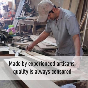 Puede incluir: Un hombre con una camisa gris y una gorra de b&eacute;isbol marr&oacute;n mide cuidadosamente un trozo de madera en un taller. El texto "Made by experienced artisans, quality is always censored" es visible en la imagen.