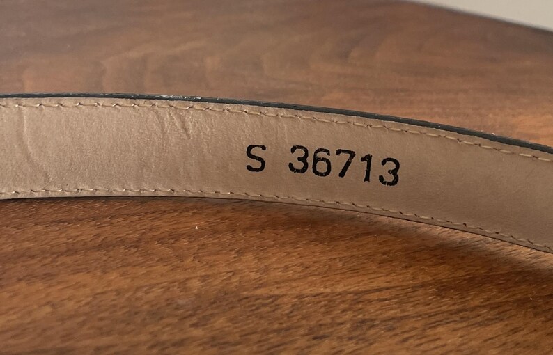 Pu&ograve; includere: Una tazza di ceramica bianca con manico nero e la scritta "But First, Coffee" in nero, con un carattere a mano. La tazza &egrave; su una superficie bianca.