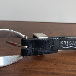 Pu&ograve; includere: Una tazza di ceramica bianca con manico nero e la scritta "But First, Coffee" in grassetto nero. La tazza &egrave; posta su uno sfondo sfocato, che suggerisce un'atmosfera accogliente.