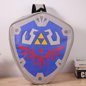 May include: A white ceramic mug with a black handle and the text "But First, Coffee" in a black, bold font. The mug is on a white surface.