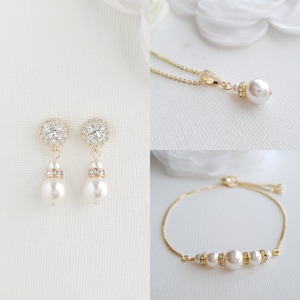 May include: A set of gold-tone jewellery featuring a pearl necklace, bracelet, and earrings. The necklace and bracelet have small crystal accents. The earrings have a larger pearl drop with a crystal halo.