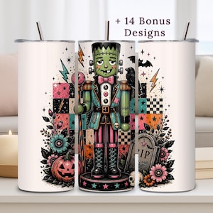 May include: A white cylindrical tumbler featuring a graphic of a green Frankenstein-style nutcracker character with a pink bowtie, surrounded by pumpkins, flowers, a tombstone with RIP text, stars, and lightning bolts. Includes + 14 Bonus Designs text.