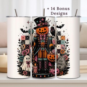 May include: Three white cylindrical tumblers with straws, featuring a central pumpkin-headed nutcracker character in a top hat, surrounded by ghosts, bats, flowers, a tombstone with the text Stay Spooky, and the text + 14 Bonus Designs.