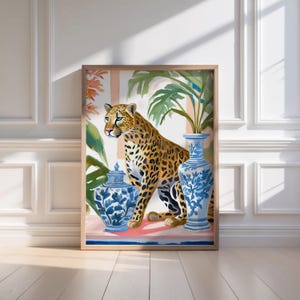 Puede incluir: Una impresión enmarcada que presenta un leopardo sentado junto a dos jarrones de porcelana azul y blanco con diseños florales. El fondo es una escena tropical con exuberantes hojas verdes y flores rosas.