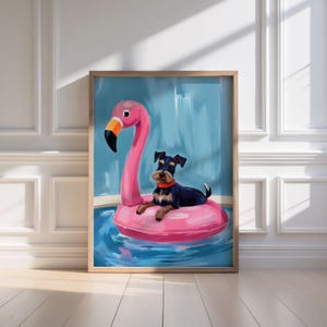 May include: A framed art print featuring a black and brown dog lounging on a pink flamingo pool float. The dog wears a red collar and rests in a pool of blue water. The background is a light blue color.