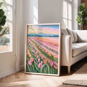 May include: A framed painting depicts a field of pink tulips under a pastel sky. The artwork features rows of flowers in varying shades of pink and green, with a light wooden frame. The background shows a landscape with mountains and a colorful sky.