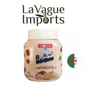 Puede incluir: Un tarro blanco con tapa marrón y una etiqueta que dice "El Mordjene Creme de Noisettes Grillees" en árabe y francés. El tarro está lleno de una crema marrón y tiene una imagen de una mujer con un pañuelo en la etiqueta. El tarro es de 700g.