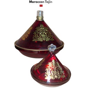 Puede incluir: Dos tajines marroquíes de vidrio hechos a mano. El más grande tiene una tapa cónica y el más pequeño un pomo de vidrio transparente. Ambos son de color rojo intenso con diseños dorados. El texto "Glass Handmade Moroccan Tajin" está en la parte superior.