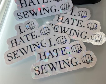 Peut inclure: Cinq autocollants irisés avec le texte "I. HATE. SEWING." et un emoji de poing.