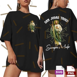 Puede incluir: Camiseta negra de gran tama&ntilde;o con un dise&ntilde;o de San Judas Tadeo en verde y blanco, con el texto "San Judas Tadeo" y "Siempre a mi lado" en blanco. El dise&ntilde;o est&aacute; impreso en la parte delantera y trasera.