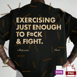 May include: Black sweatshirt with the text "EXERCISING JUST ENOUGH TO F*CK & FIGHT." in a tan color. Below the text are the words "Not for pussies" and "Frazed". The sweatshirt has a relaxed fit.