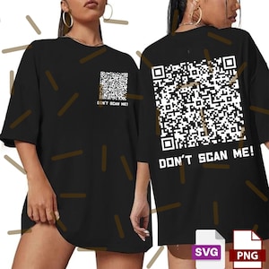 Könnte beinhalten: Schwarzes übergroßes T-Shirt mit einem QR-Code-Design auf der Vorder- und Rückseite. Der Text "DON'T SCAN ME!" ist unter den QR-Codes aufgedruckt. Das Shirt hat kurze Ärmel und eine lockere Passform.