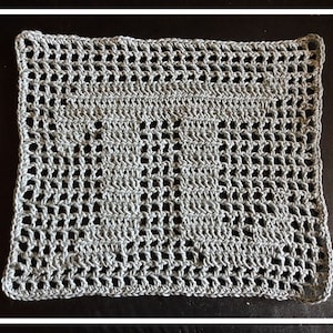 May include: A rectangular, open-weave crochet piece in a light gray color. The handmade textile features a repeating pattern of small, evenly spaced holes, creating a delicate, airy texture. The edges are neatly finished with a defined border.