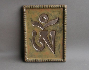 Om (Tibetan version) imprinted in gold on a stoneware hanging tile