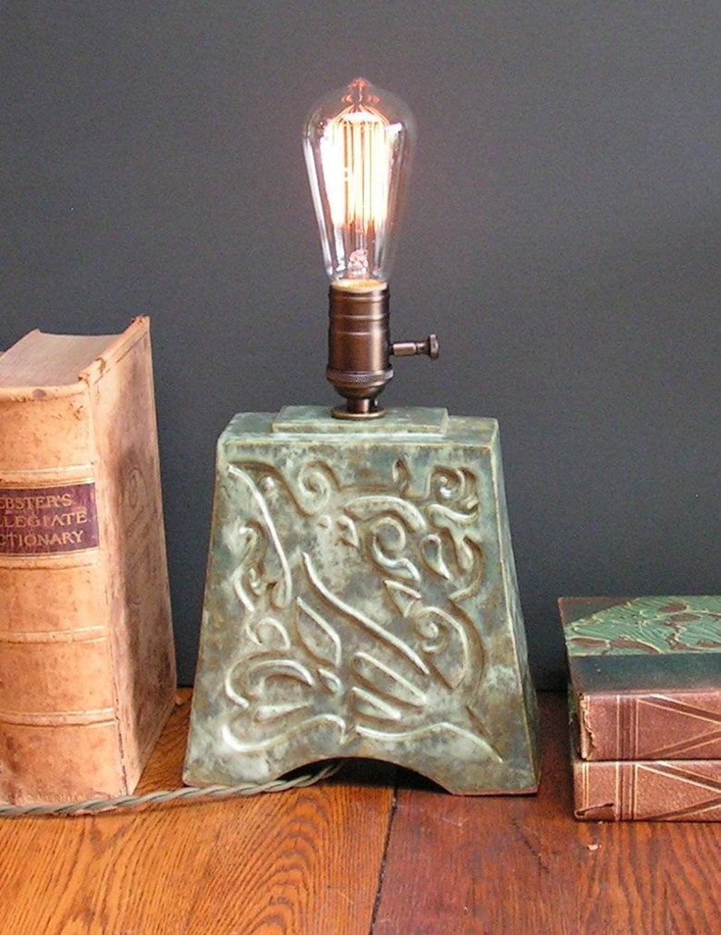 and indented Art Nouveau design of a bird mottled green glaze Stoneware lamp with vintage Edison bulb
