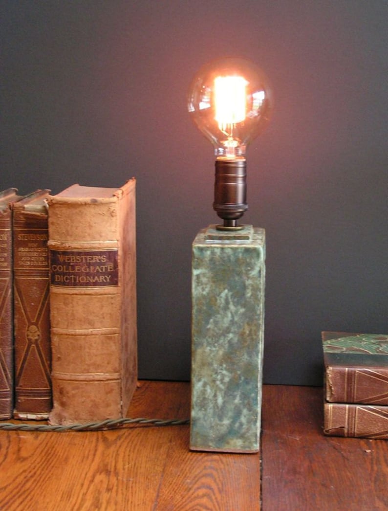 and indented Art Nouveau design of a bird mottled green glaze Stoneware lamp with vintage Edison bulb