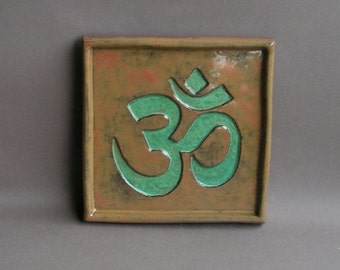 Om symbol (Hindu version) imprinted in copper patina glaze on a hanging stoneware tile