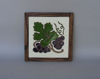 Oak-framed stoneware trivet with Arts & Crafts grape leaf and grapes