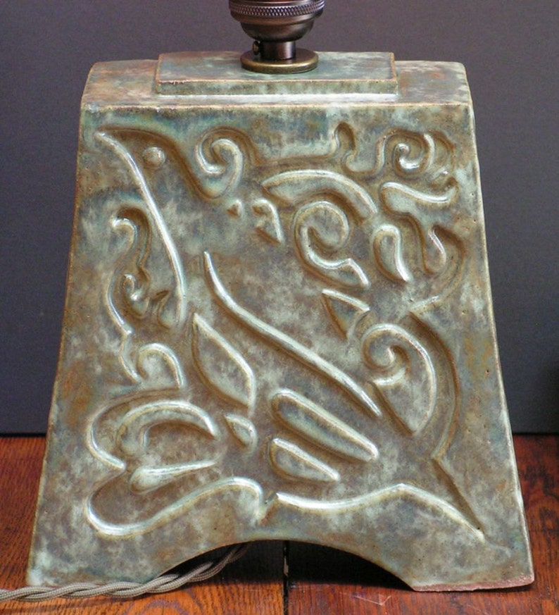 and indented Art Nouveau design of a bird mottled green glaze Stoneware lamp with vintage Edison bulb