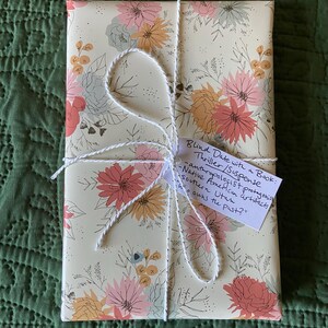 This image shows an exemplar of one of the books wrapped in floral paper in the genre thriller/suspense.