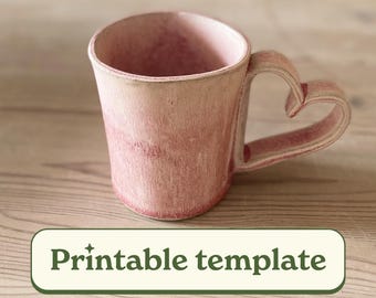 May include: A pink ceramic mug with a heart-shaped handle. The mug has a textured surface and a gradient color, transitioning from a lighter pink at the top to a deeper shade at the base. The text "Printable template" is in a green box.