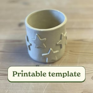 May include: A white ceramic planter with a star pattern. The planter is empty and ready to be filled with plants. Printable template.