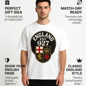 May include: White t-shirt with a large, distressed emblem that reads "ENGLAND EST. 927". The emblem incorporates the English flag, a crown, a rose, and a lion. The shirt is a classic style.