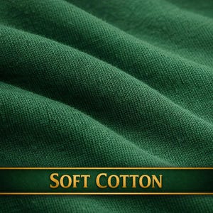 May include: Close-up of a textured, forest green fabric with soft folds. A dark green banner with gold lettering reads "SOFT COTTON". The fabric appears to be a knit or woven material, suggesting a textile product.