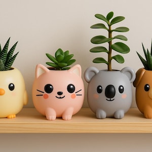 May include: Four ceramic animal-shaped plant pots with succulents. The pots are a yellow chick, a pink cat, a grey koala, and a brown dog. Each pot has a smiling face and sits on a wooden shelf.
