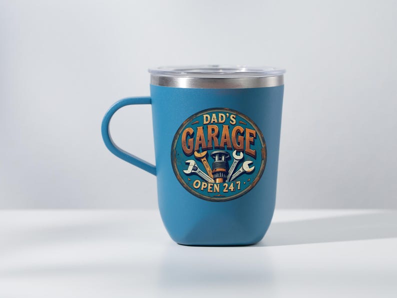 Może przedstawiać: Niebieski kubek termiczny ze stali nierdzewnej z pokrywką. Kubek ma grafikę z vintage'owym znakiem, na kt&oacute;rym widnieje napis "Garage Taty Otwarte 24/7" wraz z narzędziami i częścią samochodową.