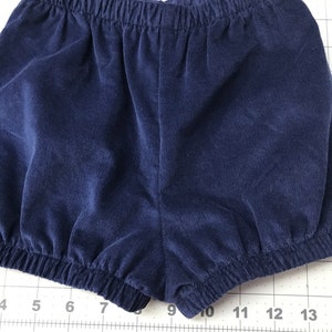 May include: A pair of navy blue corduroy shorts with a gathered elastic waistband.