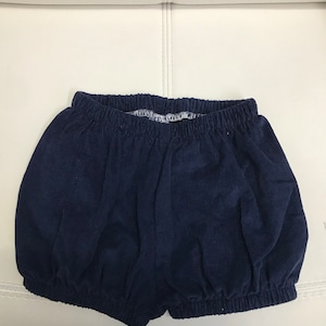 May include: A pair of navy blue corduroy baby bloomers with an elastic waistband.