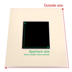 May include: A cream-colored mat with a black rectangular opening. The mat has text that reads "Aperture size 6mm smaller than artwork".
