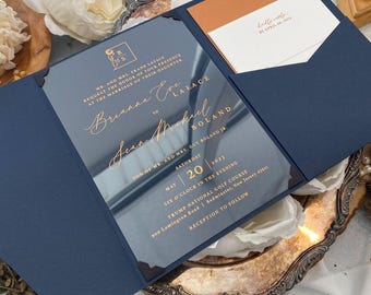 Puede incluir: Una invitación de boda azul marino con un inserto de acrílico transparente con letras doradas. La invitación dice "Mr. and Mrs. Frank LaFace request the honor of your presence at the marriage of their daughter Brianna Eve LaFace to Sean Muskul Boland Son of Mr. and Mrs. Guy Boland Jr. May 20, 2023 Six o'clock in the evening Trump National Golf Course 900 Lamington Road Bedminster, New Jersey 07931 Reception to follow".