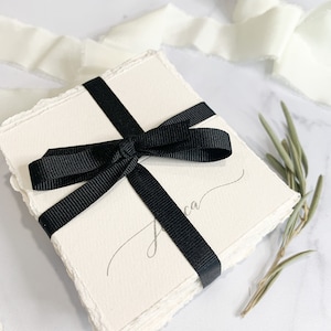 a black and white wedding card with a bow