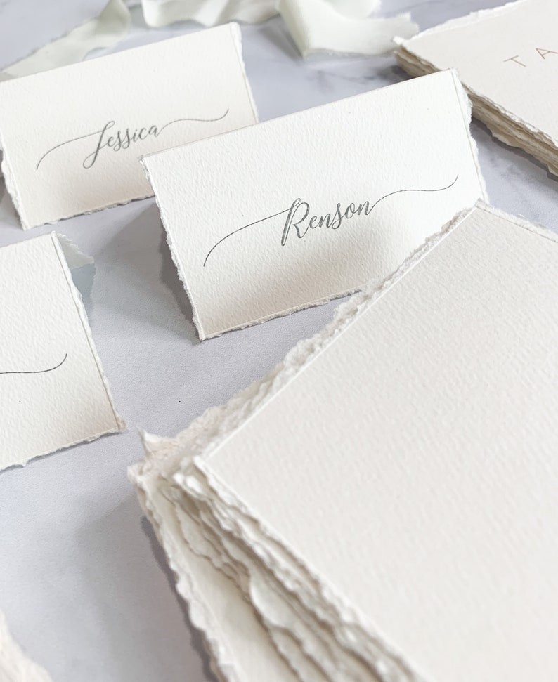 a table topped with lots of white place cards