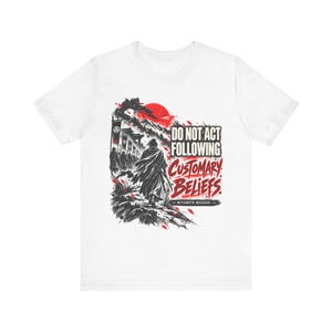 May include: A white short-sleeve t-shirt featuring a black and red graphic of a samurai walking toward a mountain and a red sun. The text reads DO NOT ACT FOLLOWING CUSTOMARY BELIEFS and MIYAMOTO MUSASHI in black and red stylized lettering.