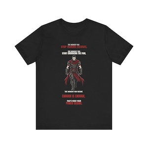 May include: A black short-sleeved t-shirt featuring a graphic of a warrior in red and black armor. The text reads: THE MOMENT YOU STOP MAKING EXCUSES, THE MOMENT YOU START EMBRACING THE PAIN, THE MOMENT YOU DECIDE ENOUGH IS ENOUGH, THAT'S WHEN YOUR POWER BEGINS.